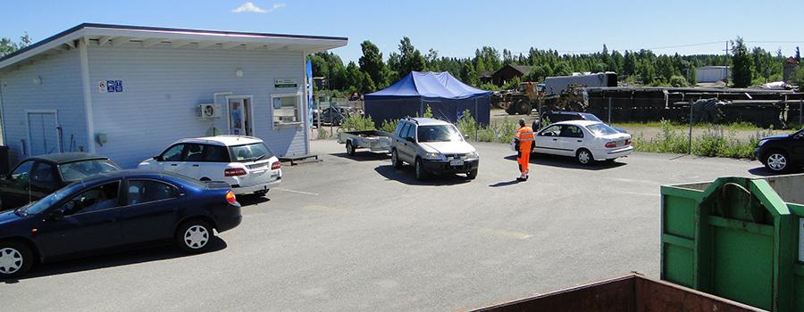 Kuvassa Orimattilan jäteaseman vastaanottorakennus ja jätelavoja sekä muutamia autoja odottamassa vuoroaan ja asioimassa jäteasemalla.