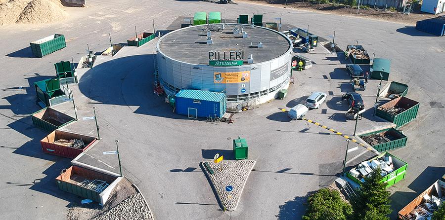 Ilmakuva Lahden jäteasema Pilleristä, jossa pyöreä rakennus ja sen ympärillä lajittelulavat eri jätelajeille.